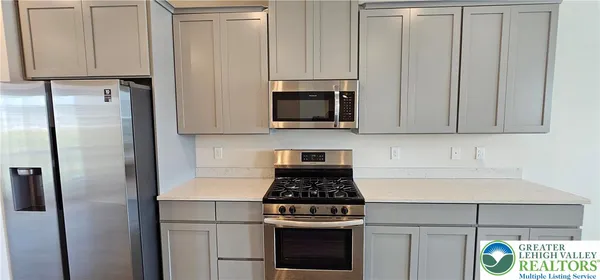 a kitchen with stainless steel appliances white cabinets and a stove top oven