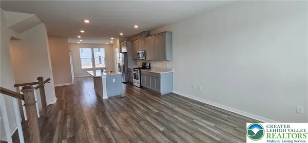 a kitchen with a sink and wooden floor
