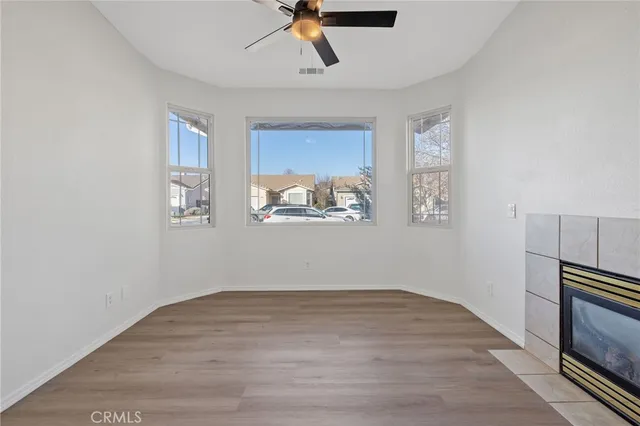 a view of empty room with wooden floor and window