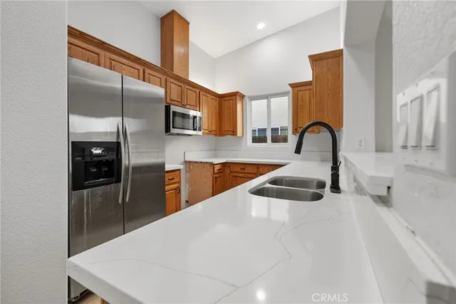 a kitchen with stainless steel appliances kitchen island a sink a refrigerator and cabinets