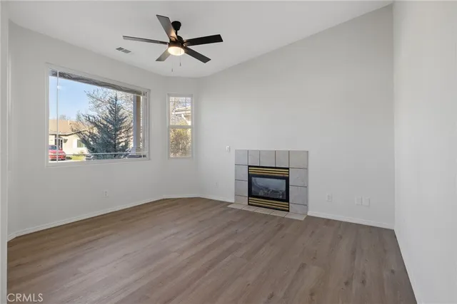an empty room with windows and a ceiling fan