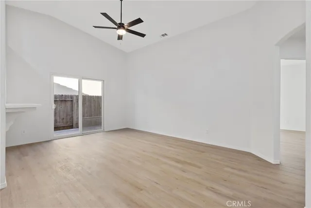 an empty room with fan and windows