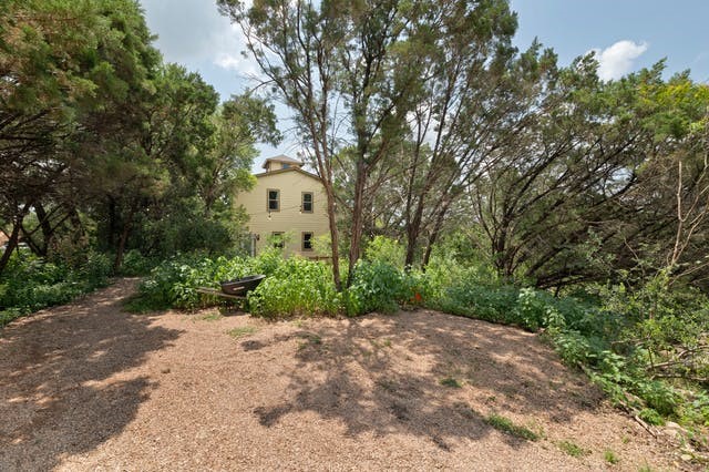 a front view of a house with a yard and shrubs
