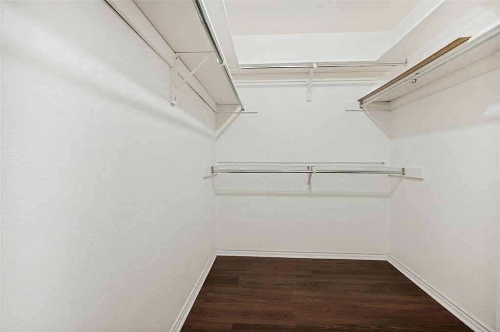 508 South Pedigo Street Pilot Point, TX 76258 - Photo 15 of 26 Walk-in closet with ample storage, featuring wood-finish flooring, white walls, multiple wire shelving units, and integrated hanging rods