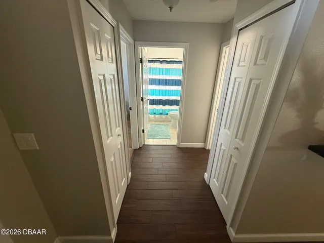 a view of a hallway with wooden floor and staircase