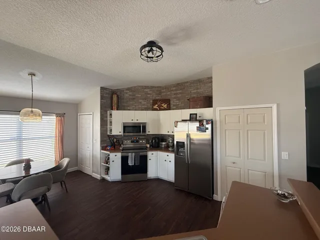 a kitchen with granite countertop a refrigerator stove and sink