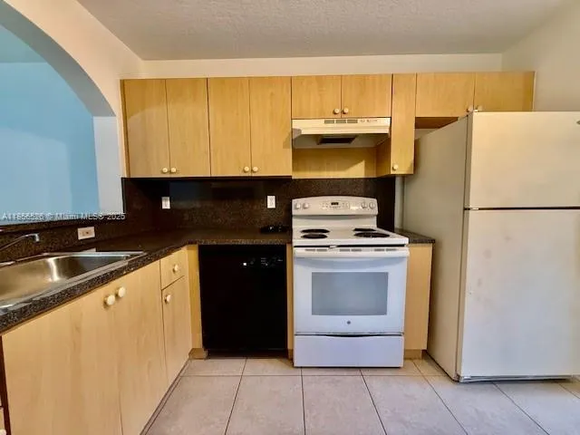 a kitchen with a sink a stove and a refrigerator