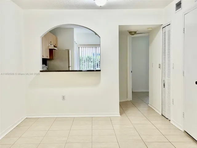 a view of a hallway with wooden floor and a living room