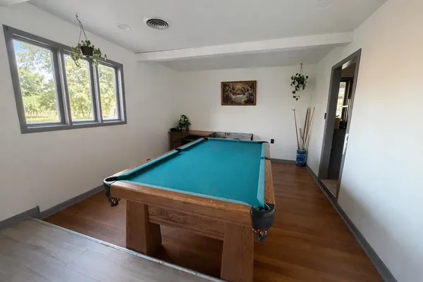 a room with pool table and windows