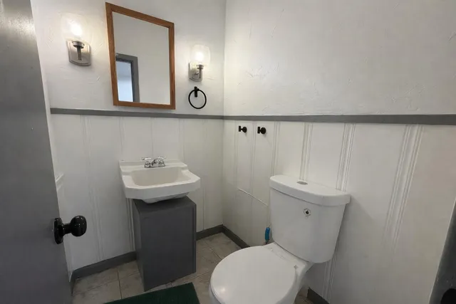 a bathroom with a sink a toilet and mirror