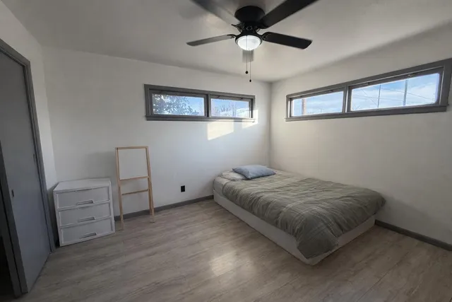 a bedroom with a bed and a ceiling fan