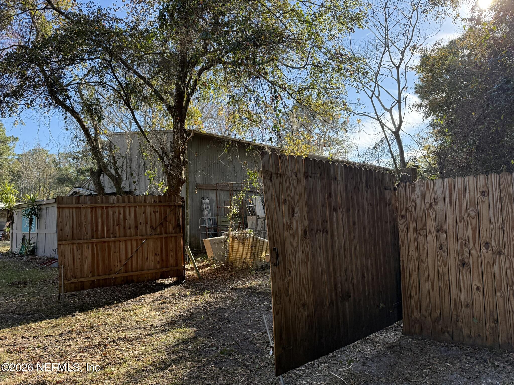 95291 Alligator Creek Road Fernandina Beach, FL 32034 - Photo 13 of 27 a view of a backyard with a trees and wooden fence