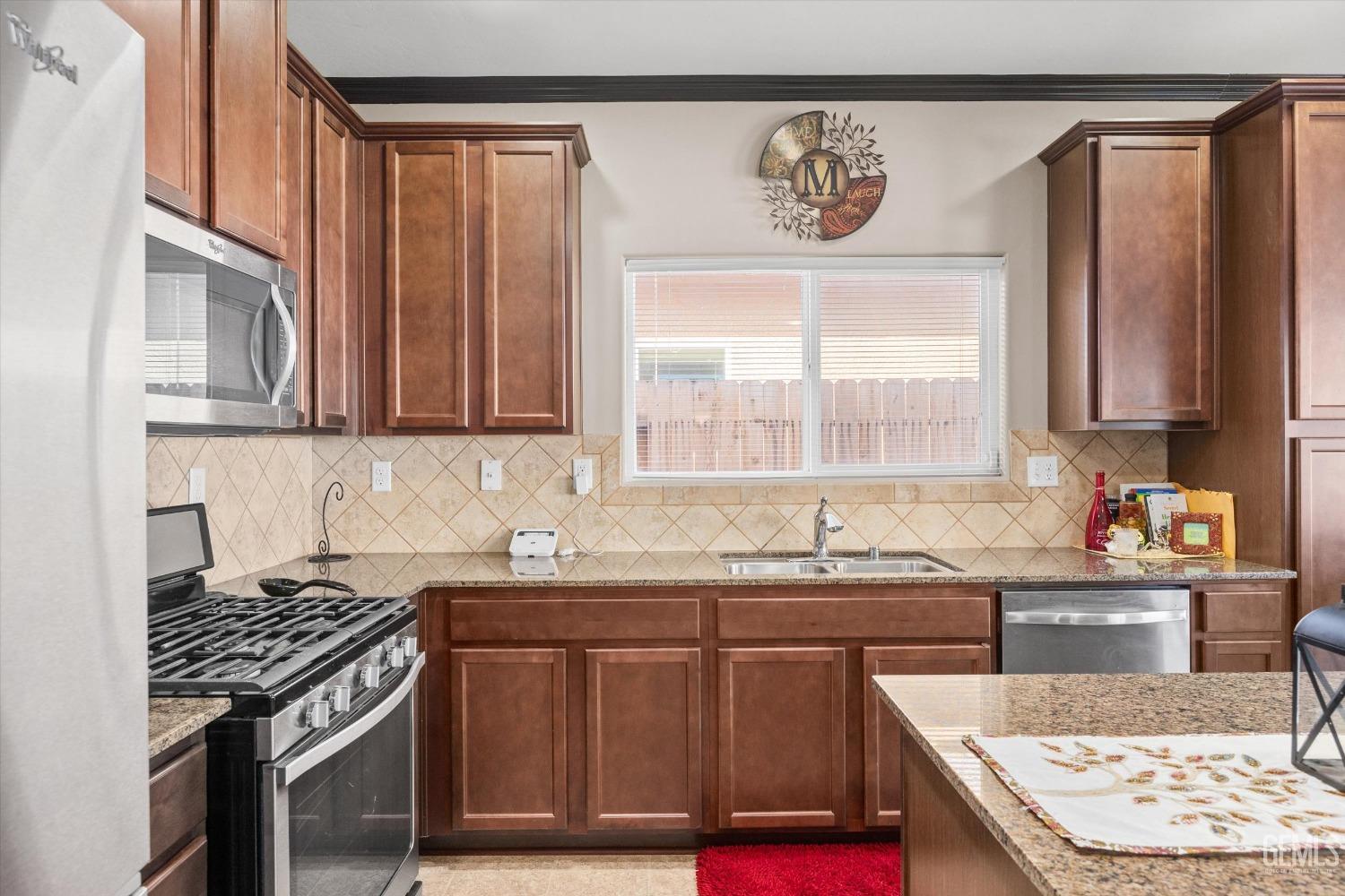 Undisclosed Address Bakersfield, CA 93313 - Photo 13 of 28 a kitchen with stainless steel appliances granite countertop a stove a sink and a microwave