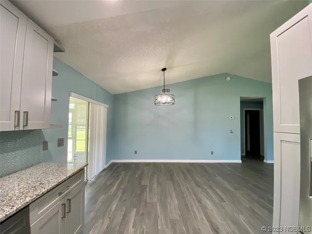 wooden floor in an empty room with a kitchen