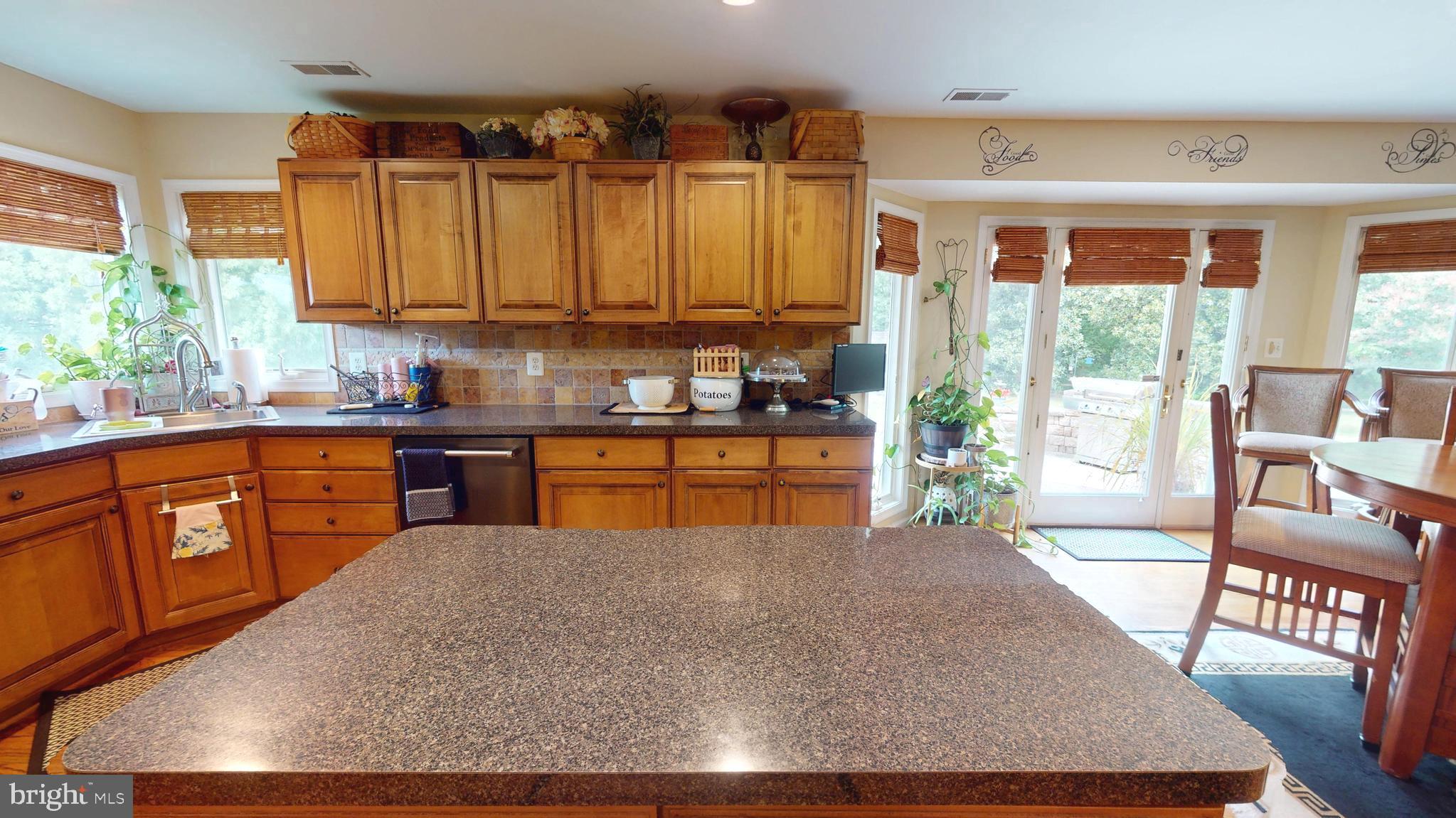 408 Laurens Way Queen Anne, MD 21657 - Photo 20 of 68 a kitchen with stainless steel appliances granite countertop a stove a sink dishwasher and cabinets with wooden floor