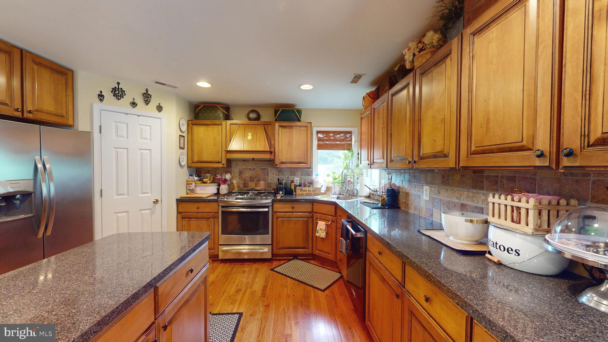 408 Laurens Way Queen Anne, MD 21657 - Photo 22 of 68 a kitchen with stainless steel appliances granite countertop a sink refrigerator and microwave