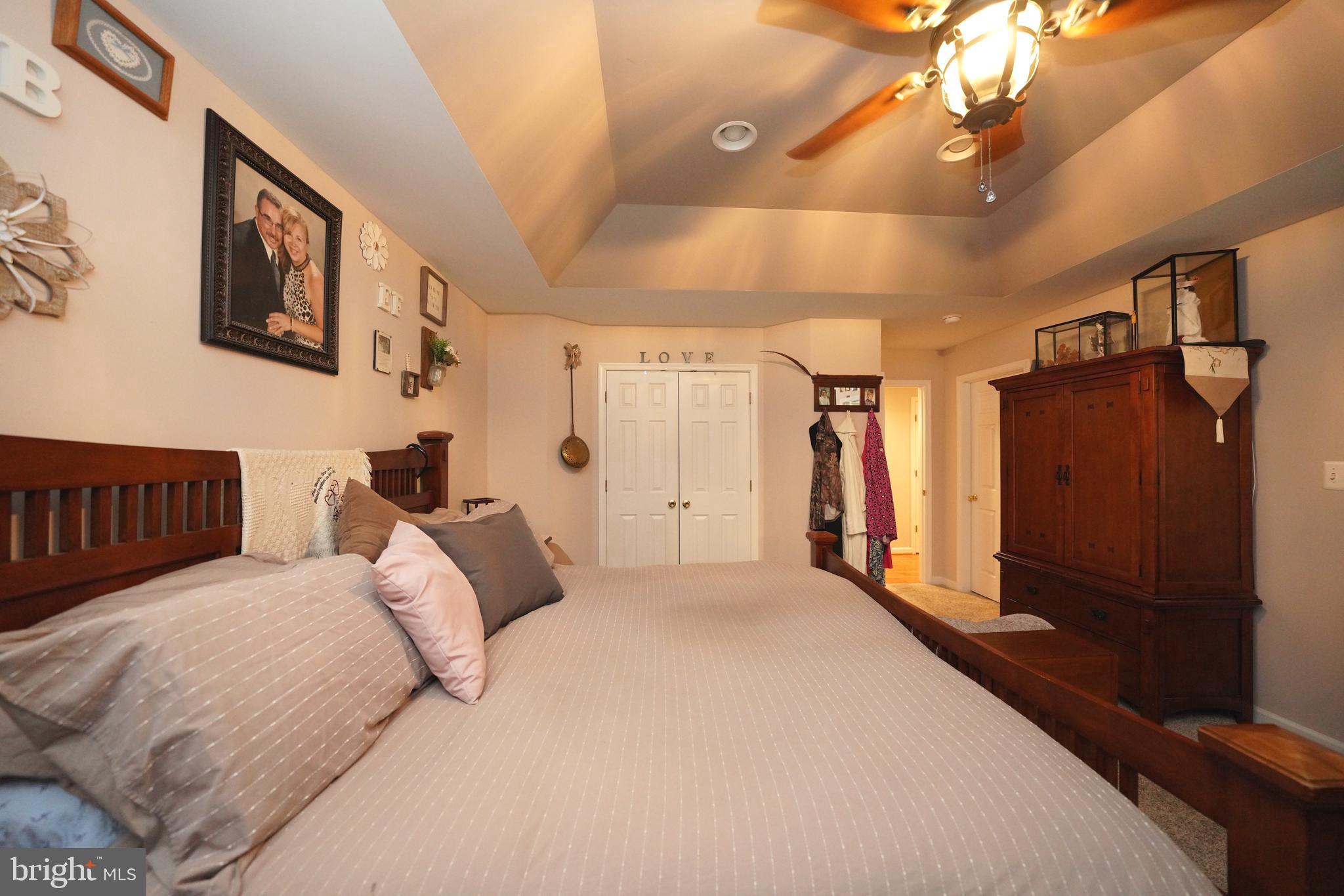 408 Laurens Way Queen Anne, MD 21657 - Photo 48 of 68 a spacious bedroom with a large bed and a chandelier