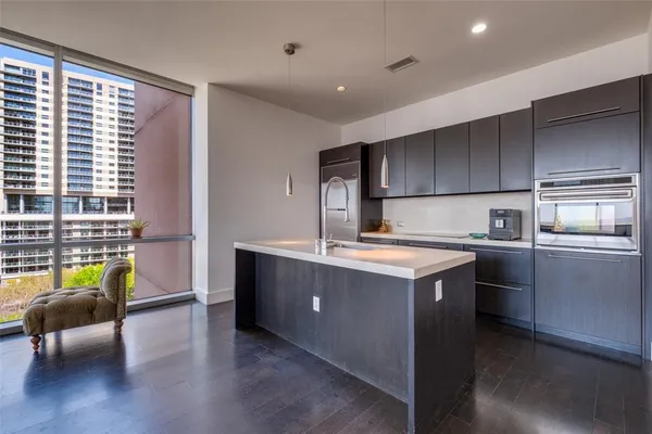 a kitchen with kitchen island wooden cabinets and stainless steel appliances