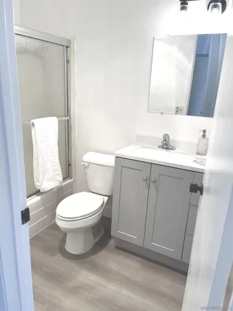 a bathroom with a toilet a sink a mirror and vanity