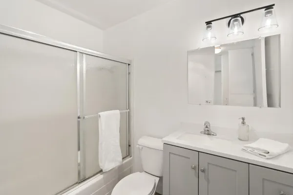 a bathroom with a sink vanity mirror and toilet