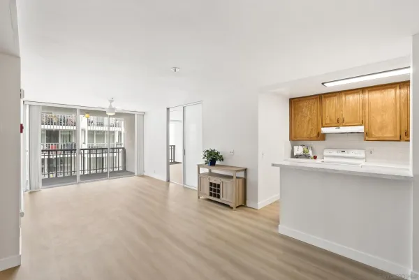 a view of a kitchen with a sink wooden cabinets and a window