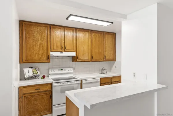 a kitchen with a sink a stove and cabinets