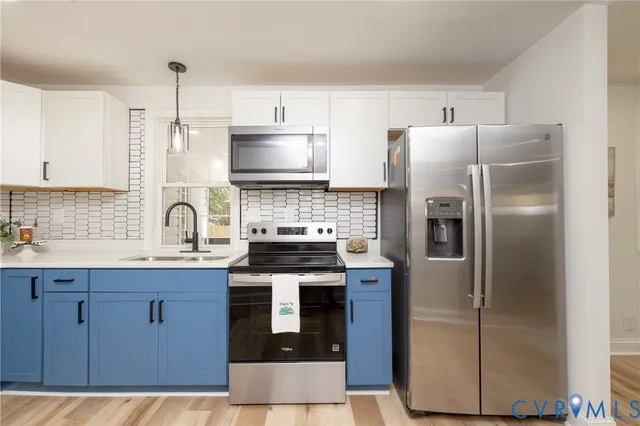 a kitchen with stainless steel appliances granite countertop a refrigerator a stove a sink and white cabinets