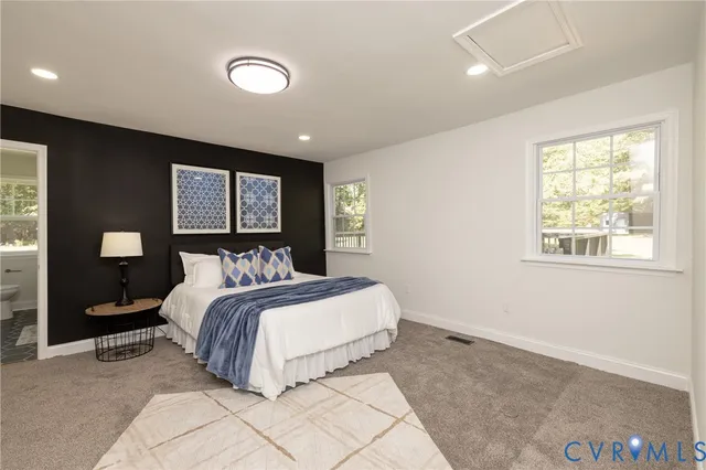 a bedroom with a large bed and a lamp