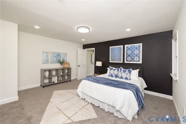 a bedroom with a bed mirror and window