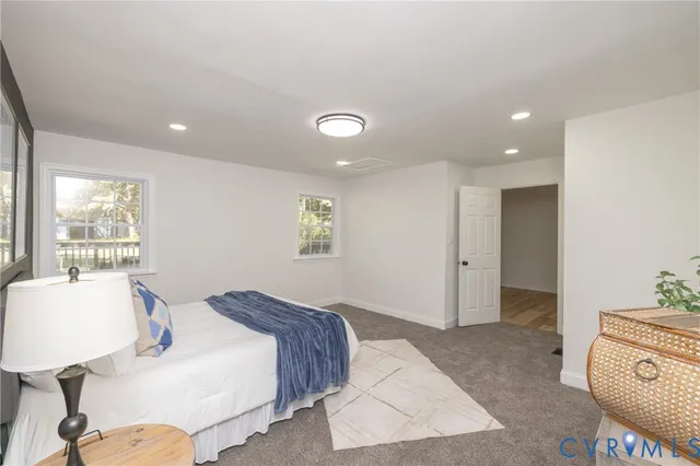 a spacious bedroom with a bed and a lamp