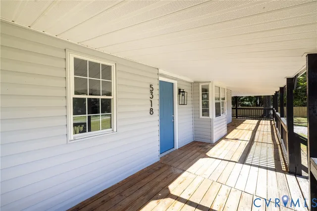 a view of balcony with wooden floor and floor to ceiling windows