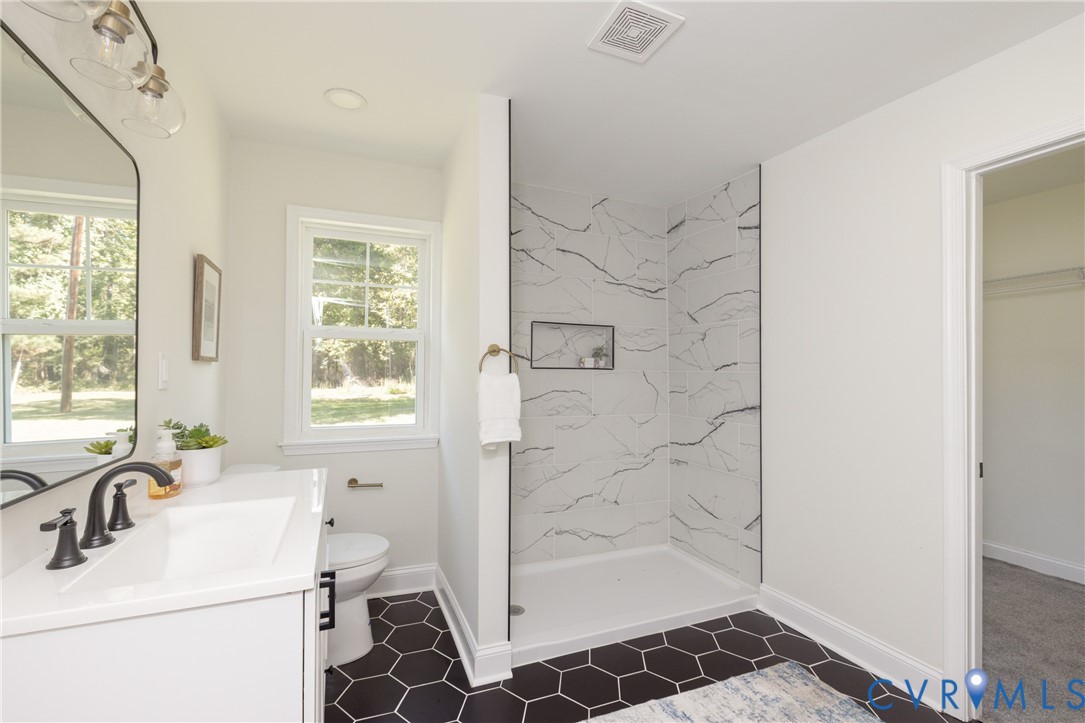 5318 Pine Hill Road Sutherland, VA 23885 - Photo 21 of 50 a bathroom with a sink a toilet a window and vanity