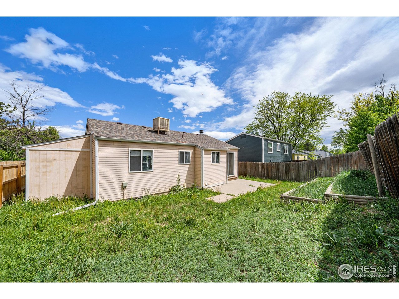 2167 Hackberry Circle Longmont, CO 80501 - Photo 23 of 23 a white house with a big yard and large trees