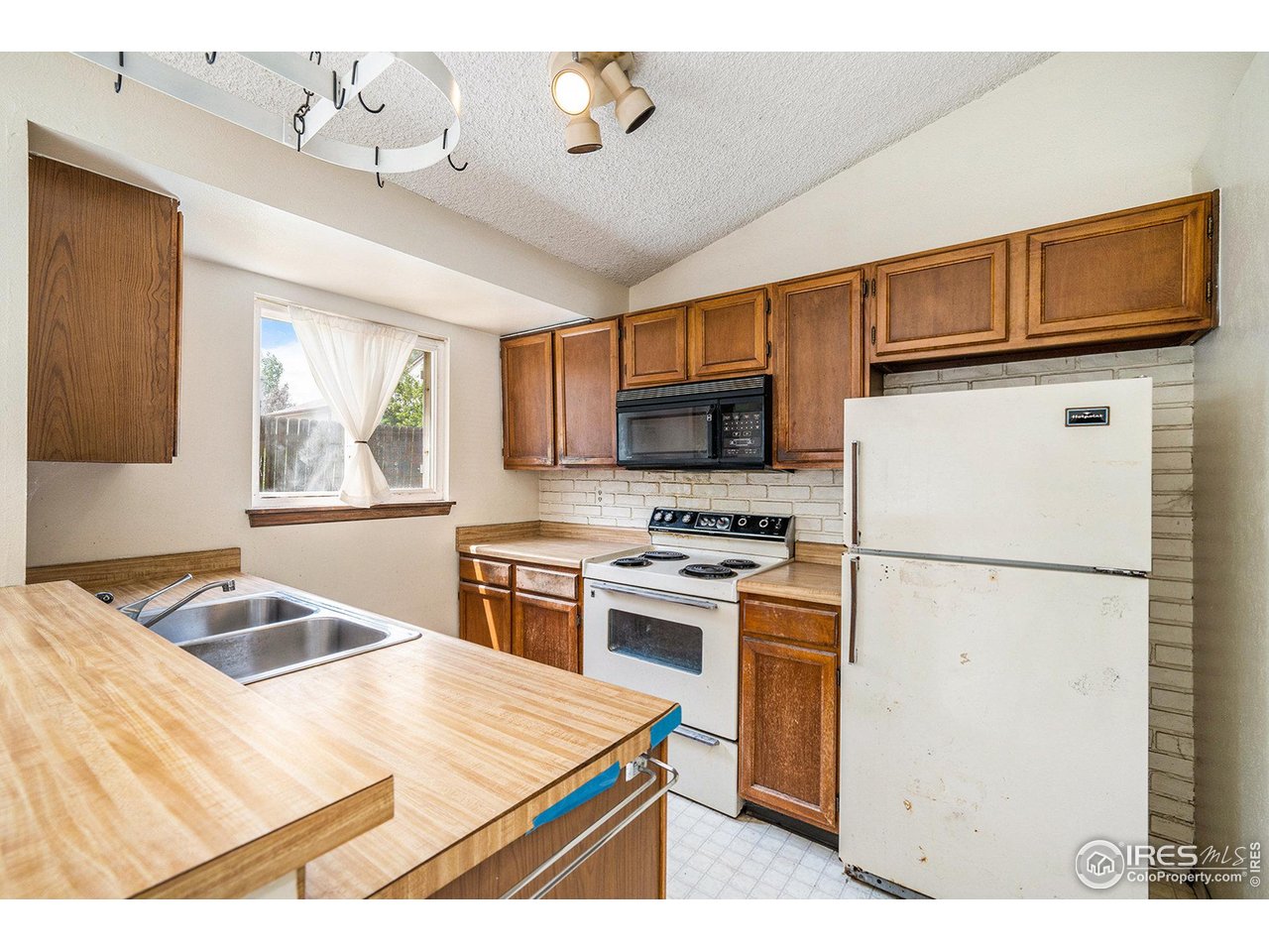2167 Hackberry Circle Longmont, CO 80501 - Photo 7 of 23 a kitchen with a stove a sink and a refrigerator