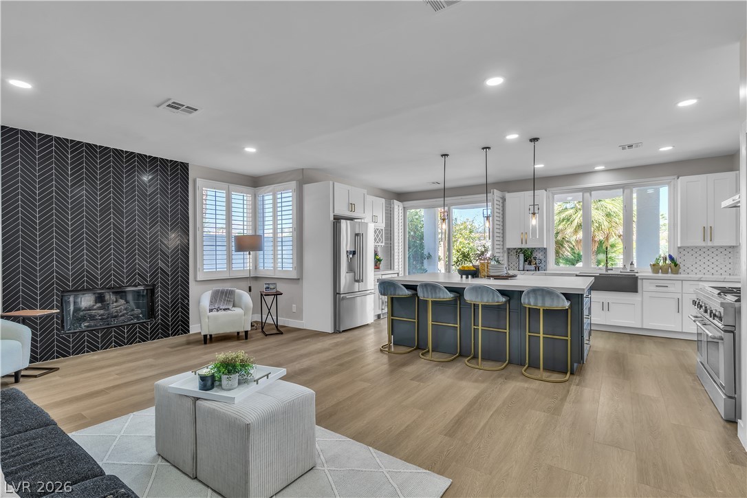 8848 Rainbow Ridge Drive Las Vegas, NV 89117 - Photo 11 of 43 An open concept living area showcasing a contemporary fireplace and a kitchen island with pendant lighting.