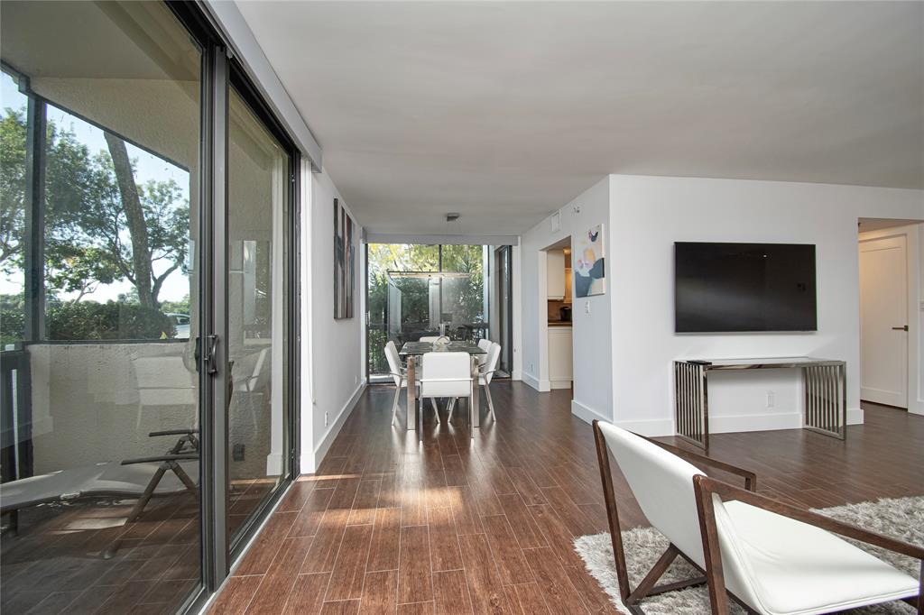 1612 Bridgewood Drive, Unit 1612 Boca Raton, FL 33434 - Photo 11 of 38 a living room with a flat screen tv and a floor to ceiling window
