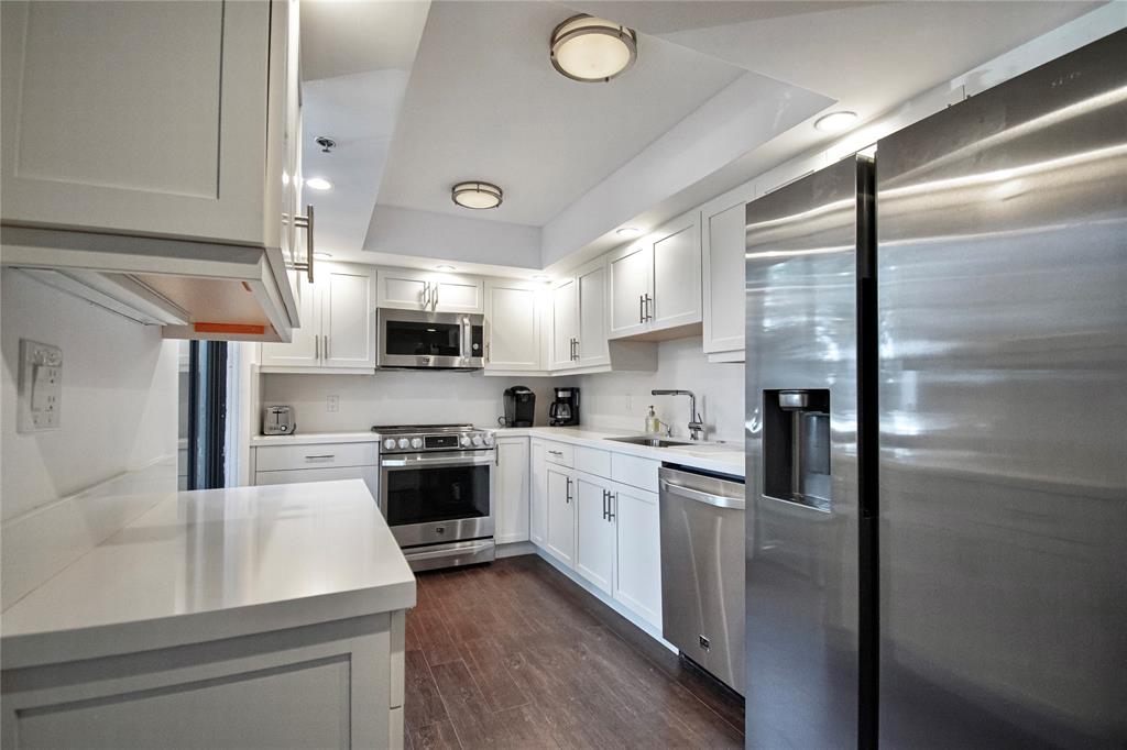 1612 Bridgewood Drive, Unit 1612 Boca Raton, FL 33434 - Photo 16 of 38 a kitchen with white cabinets and stainless steel appliances