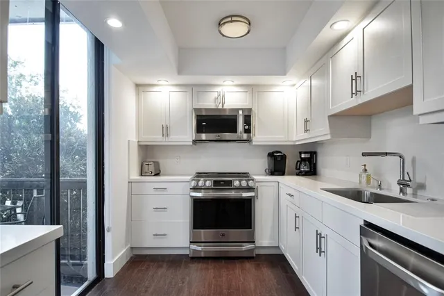 a kitchen with a sink and steel appliances