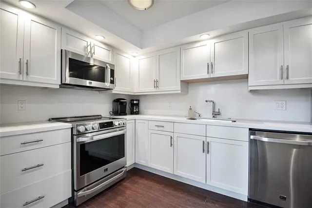 a kitchen with white cabinets stainless steel appliances and sink