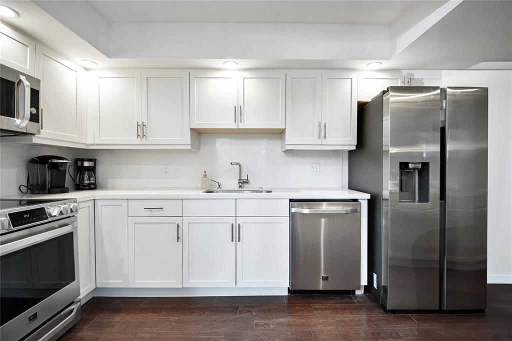 1612 Bridgewood Drive, Unit 1612 Boca Raton, FL 33434 - Photo 19 of 38 a kitchen with stainless steel appliances granite countertop a refrigerator a stove a sink and white cabinets with wooden floor