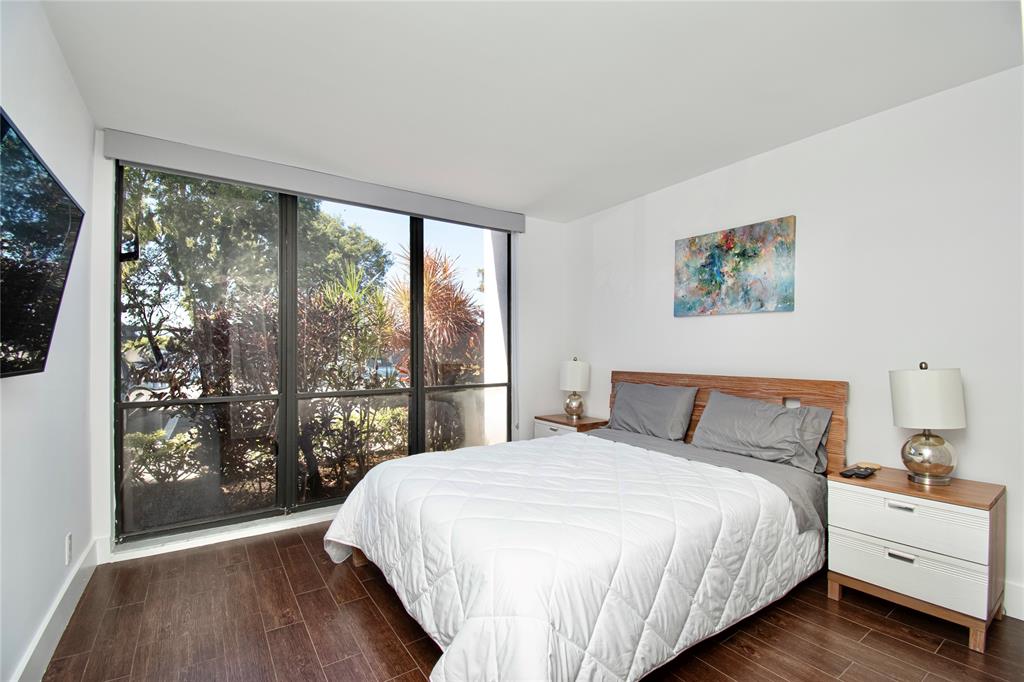 1612 Bridgewood Drive, Unit 1612 Boca Raton, FL 33434 - Photo 22 of 38 a bedroom with a large bed and a large window