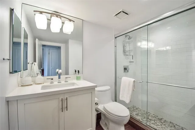 a bathroom with a sink a toilet and shower