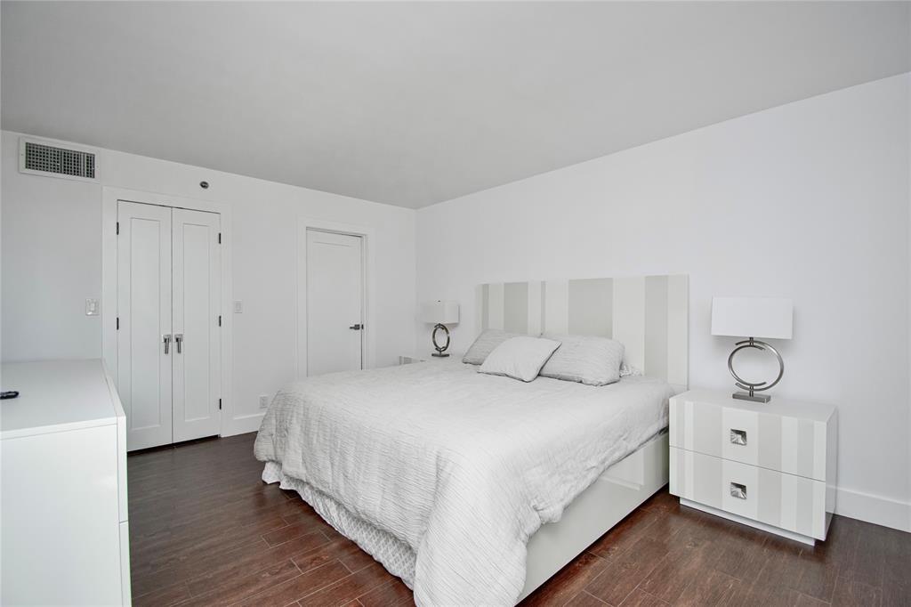 1612 Bridgewood Drive, Unit 1612 Boca Raton, FL 33434 - Photo 24 of 38 a bedroom with a bed and a chandelier