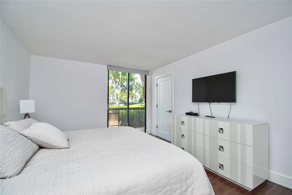 1612 Bridgewood Drive, Unit 1612 Boca Raton, FL 33434 - Photo 26 of 38 a bedroom with a bed and a flat screen tv