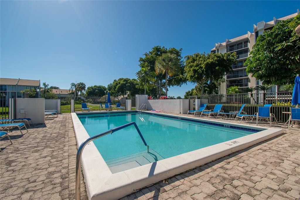 1612 Bridgewood Drive, Unit 1612 Boca Raton, FL 33434 - Photo 37 of 38 a view of a swimming pool with a lounge chairs