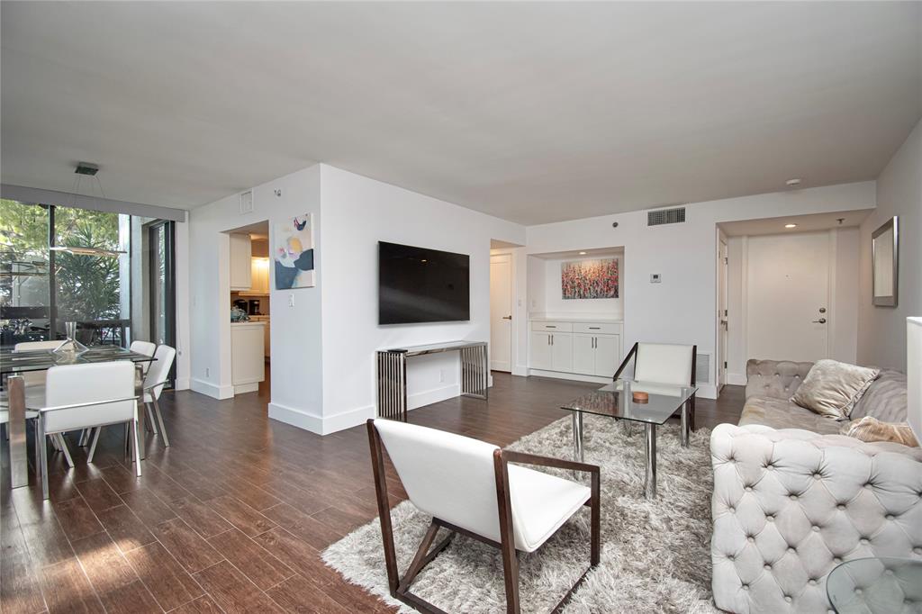 1612 Bridgewood Drive, Unit 1612 Boca Raton, FL 33434 - Photo 10 of 38 a living room with furniture a flat screen tv and a floor to ceiling window