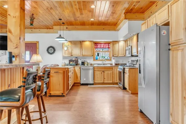 a kitchen with stainless steel appliances granite countertop a stove a sink dishwasher and cabinets with wooden floor