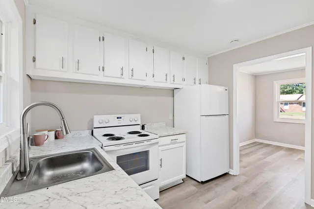 a kitchen with appliances a sink and cabinets