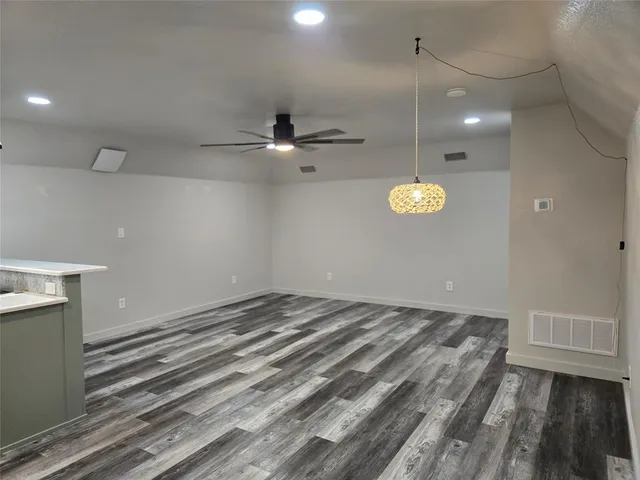 a view of a room with a ceiling fan and wooden floor