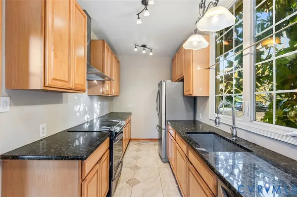 a kitchen with stainless steel appliances granite countertop a sink a stove counter space and cabinets
